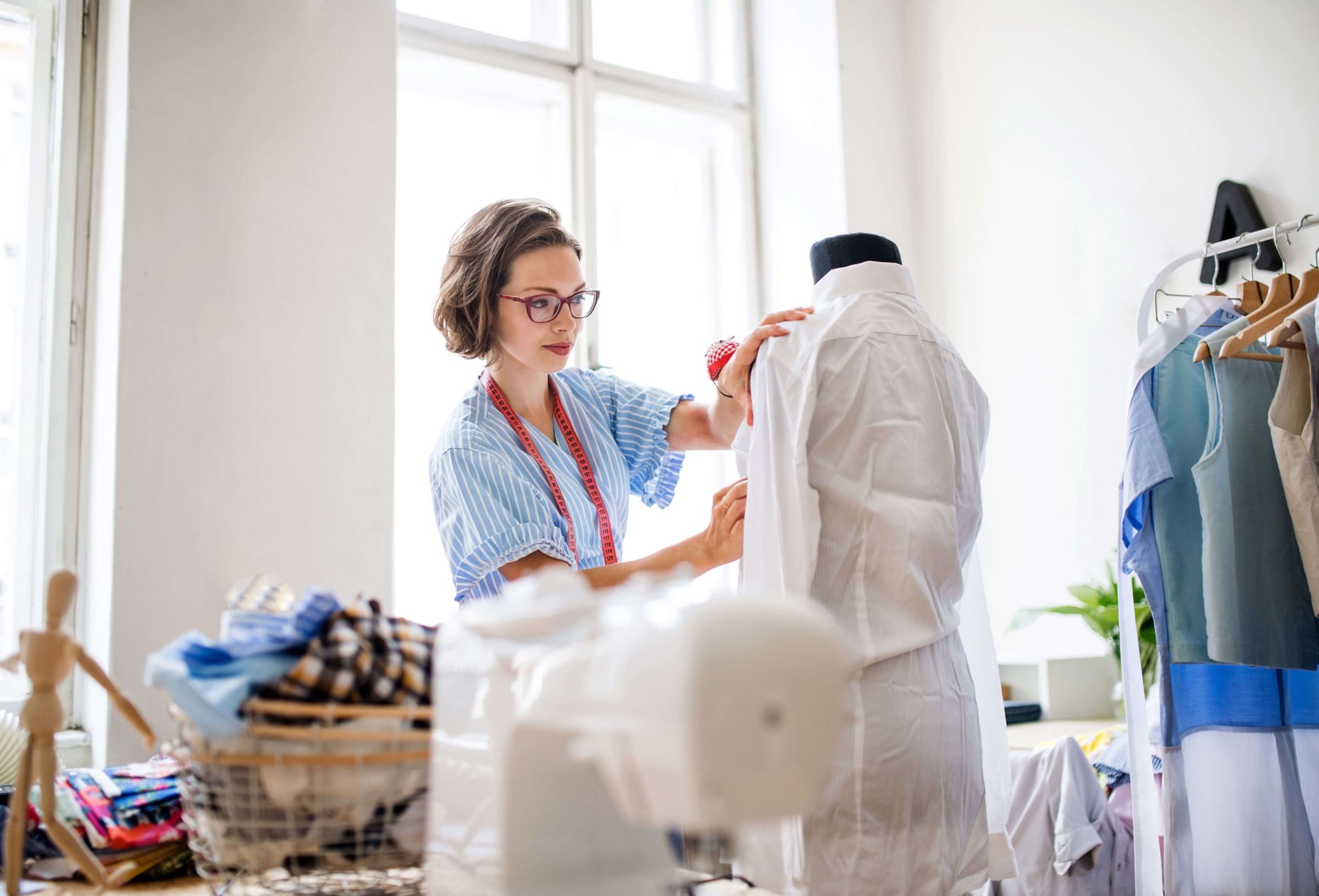 woman putting fabric on a sewing manaquin